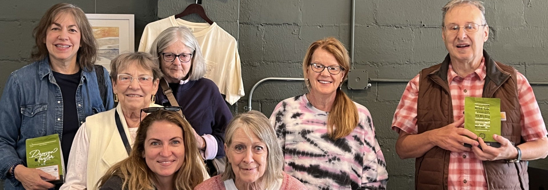 Group of people posing for a photo in front of a 'DAWSON Coffee' sign.
